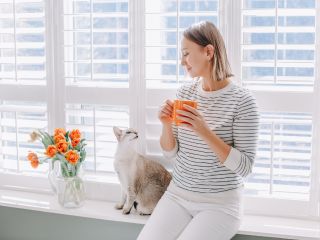 A person cleaning cordless blinds for a safe and hassle-free home environment.